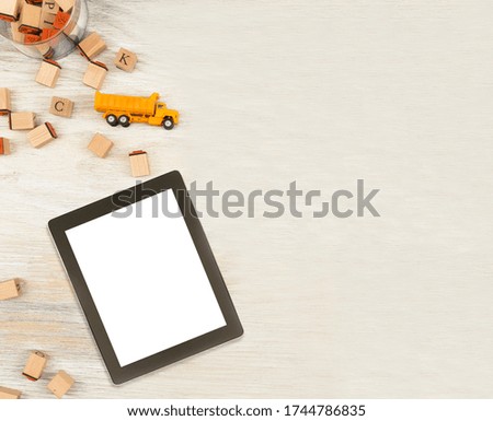 toy and tablet on white wooden floor