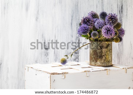 Still life with sunflower on matalic rusty cup on white wooden background