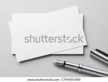 Mockup of one business card  with fountain pen at white textured paper background