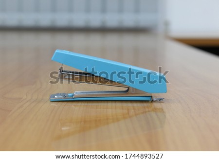 Photo of Blue stapler put on the table in office, stapler is a device used in schools or offices 