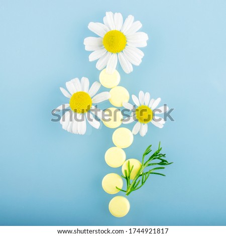 Pharmaceutical medical pills, yellow pills with chamomile flower, natural medicine concept. Soothing preparations