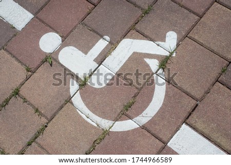 Closeup of painted white symbol of invalid area parking in the street on cobblestone