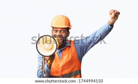 Excited African American Builder Worker Shouting In Megaphone Announcing Great Building News Standing On White Studio Background. Panorama Royalty-Free Stock Photo #1744994150