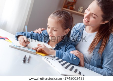 Mama helps baby learns train writing alphabet in notebook. Read book, draw letters on paper pen pencil. Store sells office supplies for pre-school student pupil. Teenager like homework. Family time.