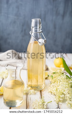 Delicious healthy refreshing beverage, sweet elderflower syrup or cordial in a glass bottle on rustic wooden background Royalty-Free Stock Photo #1745016212