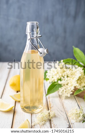 Delicious healthy refreshing beverage, sweet elderflower syrup or cordial in a glass bottle on rustic wooden background Royalty-Free Stock Photo #1745016215