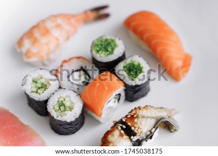 Mix of sushi and rolls close up on white background.