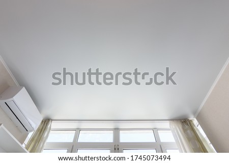 Fragment of the suspended ceiling above the window in the room, next to air conditioning Royalty-Free Stock Photo #1745073494