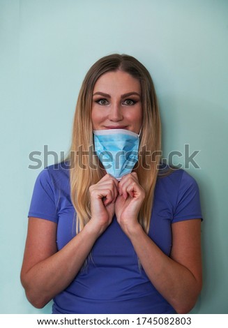 Woman is removing medical mask. Protecion from virus. End of quarantine.                               Royalty-Free Stock Photo #1745082803