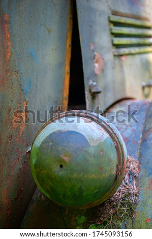 Closeup of a Headlight Cover on a Logging Truck. Abstract look at a multi colored vintage logging truck with layers of paint rusting away.