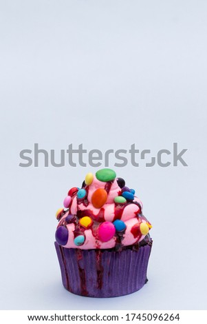 cartoon decorated cupcake on plain colored background