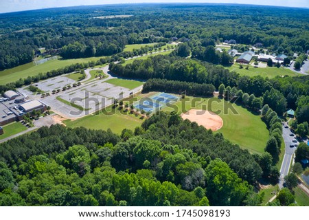 Panoramic above view of recreation center in a suburb park which has soccer field, running track, tennis courts and baseball field 