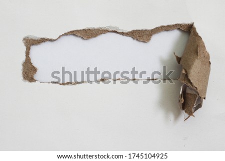 Torn hole and ripped of paper on white background
