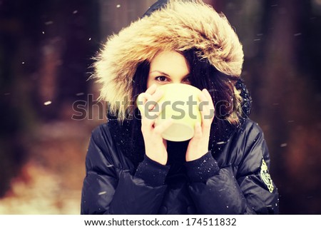 Woman with big mug of hot drink during cold day. 