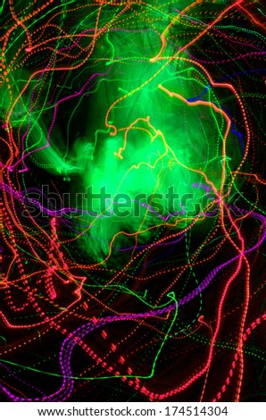 Abstract red, purple and green neon lines and a nebulosity on a black background
