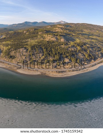 Panorama view of Yukon Territory in northern Canada by aerial drone view in spring time with stunning pristine water and mountains. 