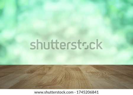 wood table background with abstract blurred soft light fresh green nature background, mock up for green eco environmental friendly product display. soft light tone image.