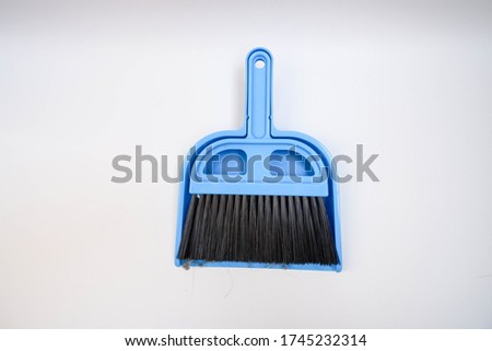 A small blue wastebasket and a blue broom on a white background for easy housekeeping