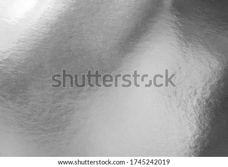 Silver gray foil texture background with shadows, highlights and glossy uneven surface Royalty-Free Stock Photo #1745242019