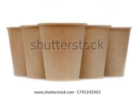 Brown paper cup for coffee, tea, a drink from environmental materials on a white background. A pile of glasses in the form of a bowling skittle. Glasses in the form of a pyramid front and top view