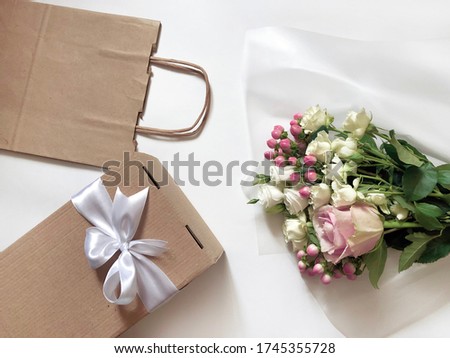 Pink Flowers, Craft Paper Bags and Boxes on the White background. Concept of Delivery Service Packing Order for Customer.