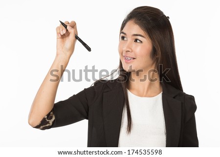 A portrait of an Asian Woman in business formal black suit is writing something in the air a with smile and think something. Isolated on white background. Close up half body.