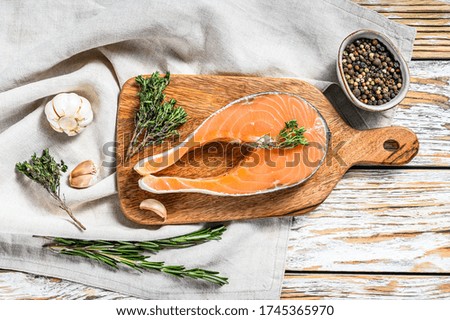 fresh raw salmon steak with pepper and thyme. White wooden background. Top view