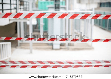 Red and white warning tape stretched across danger area in the building