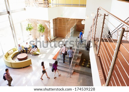 Reception Area Of Modern Office Building With People