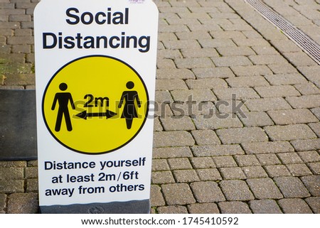 The word social distancing written on white board in Kendal