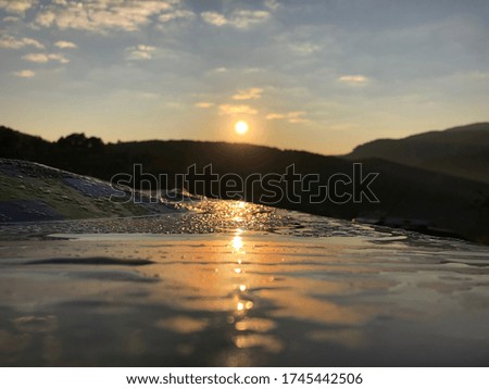 It is a picture of the morning, the sunrise reflected with water droplets on the object.