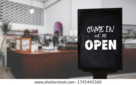Come in We’re Open’ on cafe waiter standing in front of coffee shop vintage retro sign Open sign at coffee