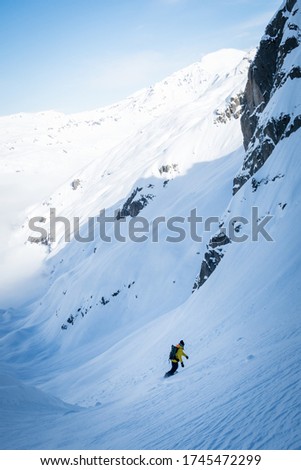 A vertical picture of a skier on the snowy mountain under the sunlight