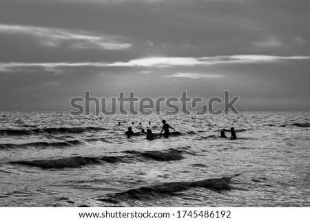 Seascape of people swimming in the sea with black and white photography