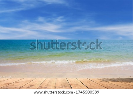 Old wooden board on a beautiful beach, natural blurred background