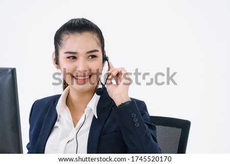 Portrait confident Asian business woman call center staff at office desk talking on phone with client. female operator agent with headsets, customer service or technical support with copy space
