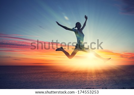 Silhouette of dancer jumping against city in lights of sunrise Royalty-Free Stock Photo #174553253