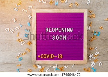 Reopening soon text on purple letter board. Business concept. Service, restaurant, shop and cafe re-opening. Reopening of the place after the quarantine due to covid-19. Message. New rules, we're open