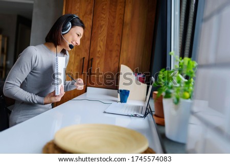 Young Woman Sitting in front of Laptop Computer at Home. Distance learning. Online language courses. Working remotely