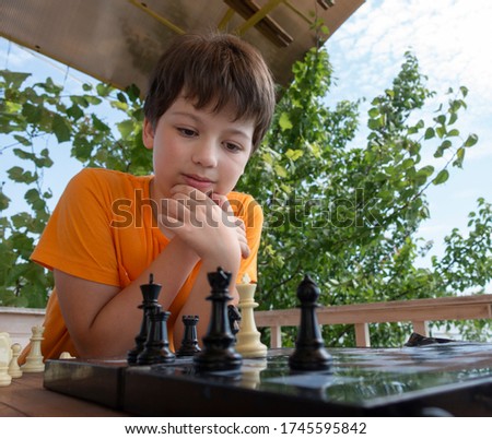 Child playing chess outdors, Young boy making a move.