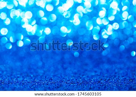 Blue glitter foil background. Shiny metal blue foil texture abstract defocused background. Sparkle glitter texture with bokeh lights
