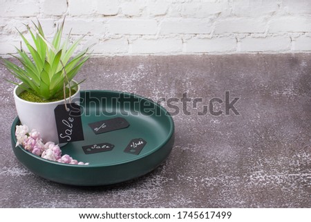The inscription sale on a green plate. Beautiful home flower.