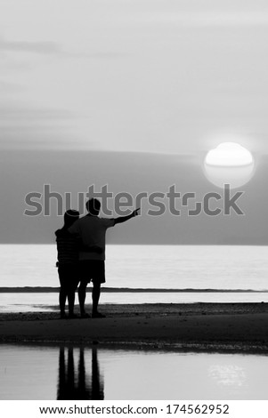 Silhouette of family on the beach during sunset.