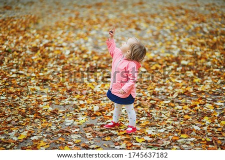 Adorable cheerful toddler girl running in Tuileries garden in Paris, France. Happy child enjoying warm and sunny fall day. Outdoor autumn activities for kids