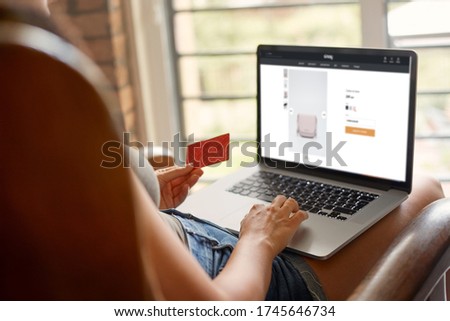 Woman holding credit card and using laptop computer. Businesswoman working at home. Online shopping. Working from home concept. e-commerce, internet banking, spending money