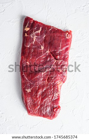 Raw skirt or flank steak,on a white stone background top view vertical Royalty-Free Stock Photo #1745685374