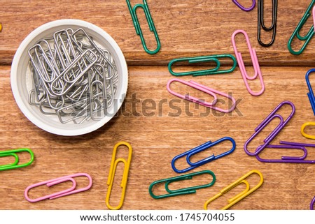 The concept of order and chaos. Disorganized colorful clips and organized silver clip.
