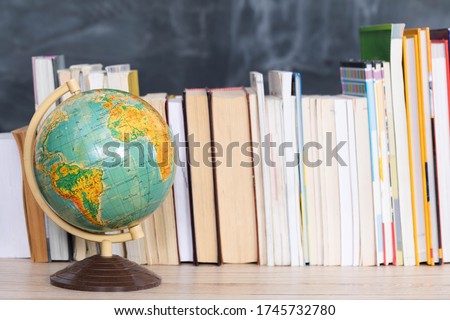 Geography lesson. A globe among a large number of school books.