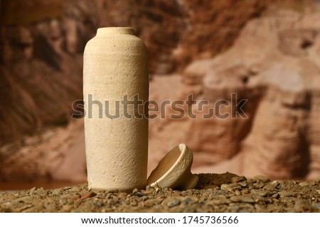 A model of a Jar used for the Dead Sea scrolls against a blurred background of the Qumran caves Royalty-Free Stock Photo #1745736566