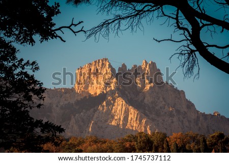 Top of Ai-Petri mountain in Crimea, view from Vorontsov park, natural photo frame. Rock lit by sun in evening at sunset. Wonderful wallpaper or background. Famous natural attraction. Panorama mount Royalty-Free Stock Photo #1745737112
